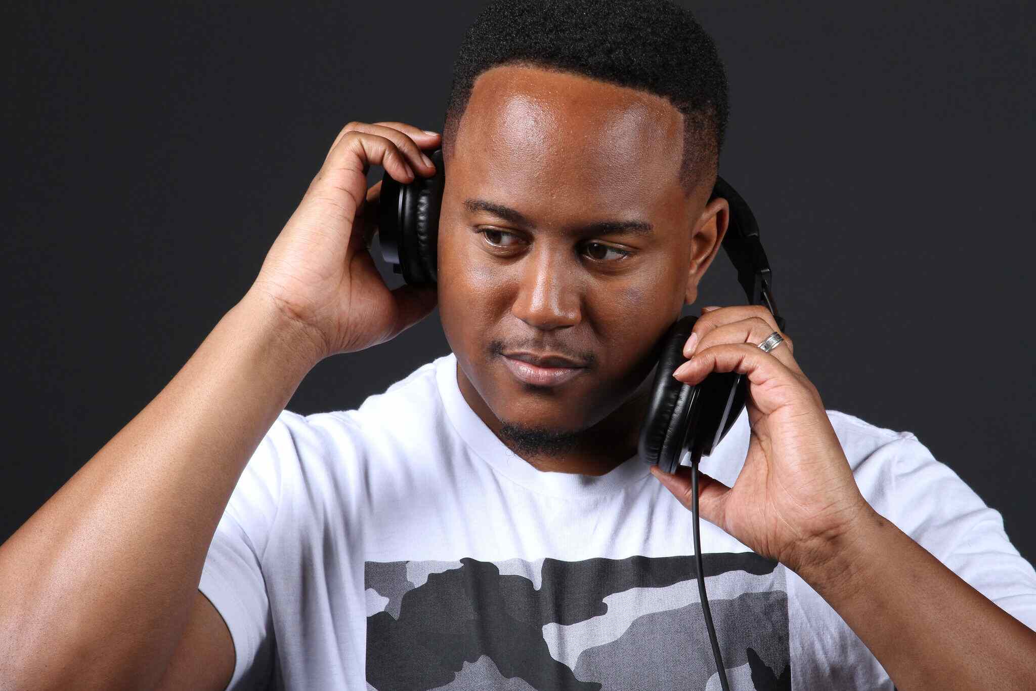 Troy Sandidge looking down tilted posing with over the head headphones.
